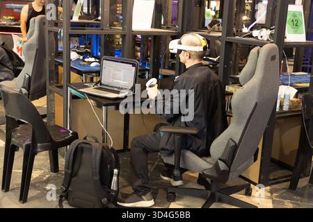 Berlin, Germany - September 09, 2025: IFA.Berlin. Man wearing virtual reality headset is engaged in gaming at a modern workspace Stock Photo