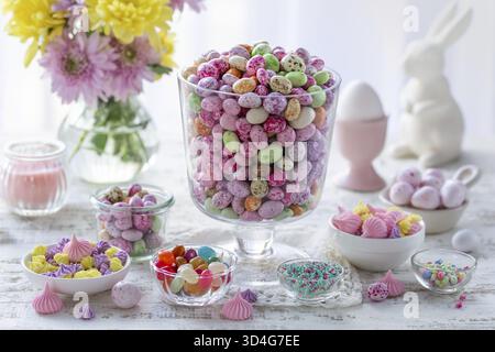 Food, Beautiful festive Easter table with colorful candy eggs, meringues, sprinkles. Happy Easter and spring holiday or sweet food concept Stock Photo