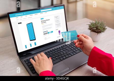 Woman shopping online for smartphone using credit card on laptop, secure internet payment and digital e-commerce technology concept Stock Photo