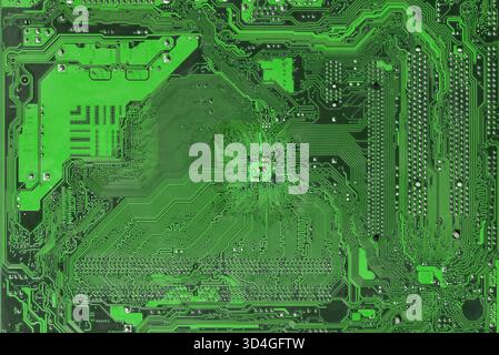 Macro shot of a green printed circuit board with detailed copper traces and solder points, representing electronics engineering, digital technology an Stock Photo