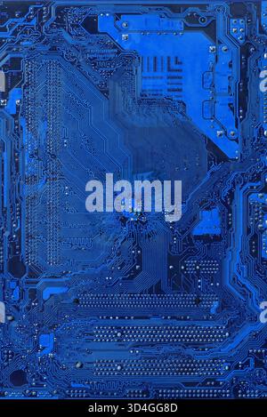 Blue vertical circuit board background showing complex network of traces and components, representing computing, communication, and futuristic digital Stock Photo