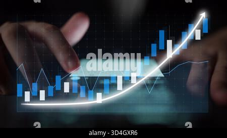 A close-up of hands working on a laptop screen displaying graphs and charts, showcasing financial growth and investment strategies in a modern Stock Photo