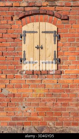 Old brick wall with new wooden shutters. Stock Photo