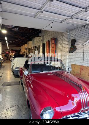 Red 1950s Pontiac convertible in auto upholstery workshop, California Stock Photo