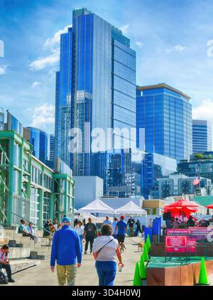 SEATTLE -SEP 18, 2025 - Downtown Seattle street scene featuring modern skyscrapers with blue glass facades reflecting the sky, people walking and gath Stock Photo