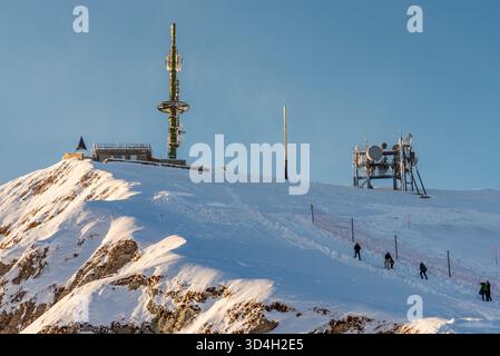 Rochers-de-Naye, Vaud, Switzerland - December 15th 2025: Telecommunication Antennas and People climbing on Snowy Mountain Summit. Stock Photo