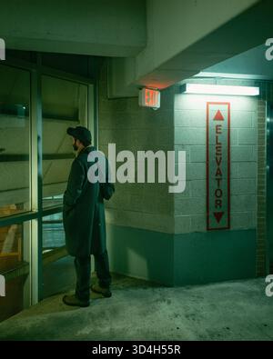A man looks out a window at night, Buffalo, New York Stock Photo