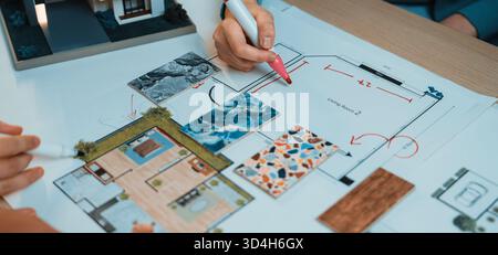 Engaging scene of hands collaborating on an architectural floor plan. Colorful swatches and detailed layout sketches showcase creative design Stock Photo