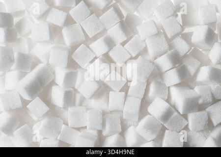 Full frame overhead view of white sugar cubes scattered densely as a background. Stock Photo