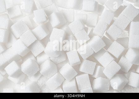 Full frame overhead view of white sugar cubes scattered densely as a background. Stock Photo
