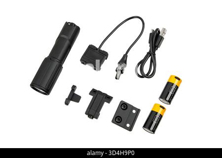 Set of black tactical flashlight, mounting accessories, cables, and two batteries on white. Stock Photo