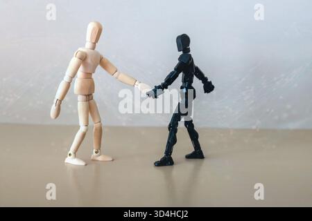 Handshake between hand of human and robot hand isolated on gray background. Future concept. Stock Photo