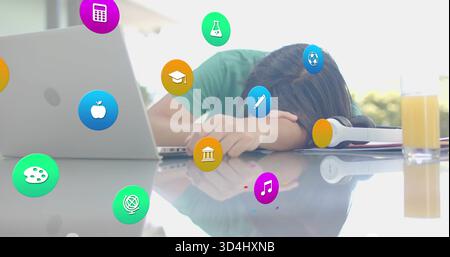 Resting green-shirted man leaning head on arms at home desk, with laptop, headphones and icons Stock Photo
