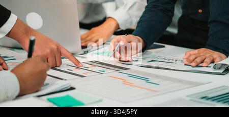 A diverse group of professionals is engaged in a productive business meeting, analyzing financial reports and data in a modern office, showcasing Stock Photo