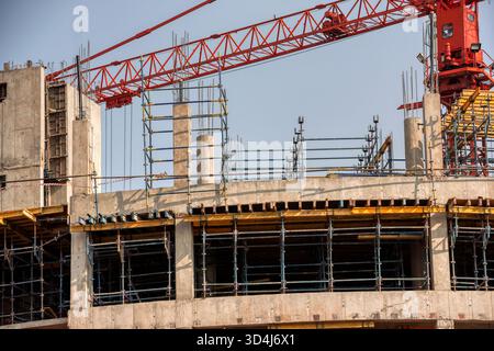 building under construction, a multi-story concrete structure with scaffolding and a large crane Stock Photo
