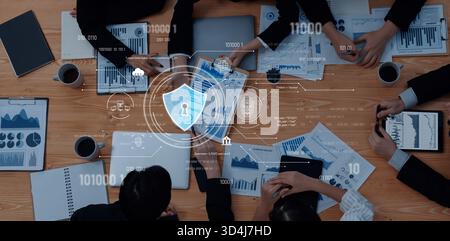 A top-down view of a business meeting focused on data security and digital analysis, showcasing professionals collaborating on charts and graphs while Stock Photo