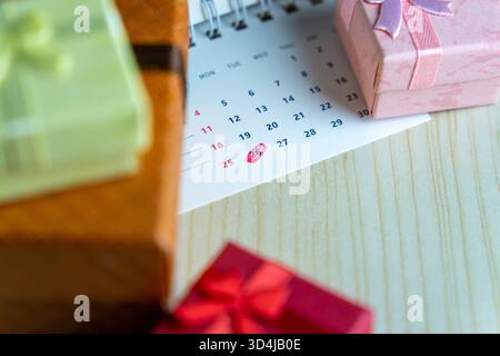 Close-up of a calendar with the 26th date circled in red surrounded by colorful gift boxes. Boxing Day celebration and post-holiday sales concept. Stock Photo