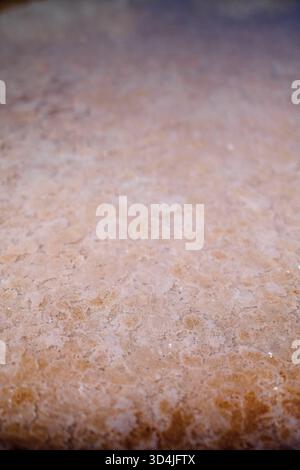 A close-up, abstract photograph capturing a textured surface with a color gradient from dark purple-brown at the top to a lighter tan-orange at the bo Stock Photo