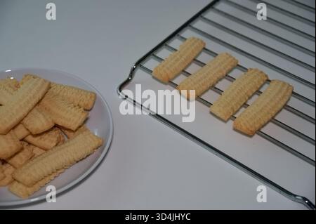 Biscuits on the plate and baking rack against white background Stock Photo