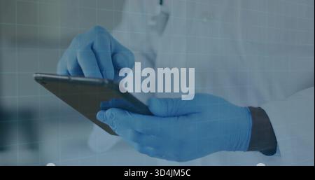 Tapping clinician's blue gloved hands swiping tablet at clinic, wearing white lab coat Stock Photo