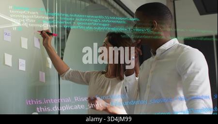 Writing two colleagues in business attire placing notes on glass, with pink marker and code overlay Stock Photo