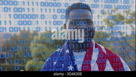 Standing Black man wearing shades draping American flag over white tee in park, showing binary code Stock Photo