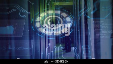 Monitoring technician wearing dark uniform inspecting racks in server room aisle, viewing HUD Stock Photo
