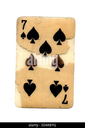 A badly damaged vintage playing card in the suit of spades isolated on ...