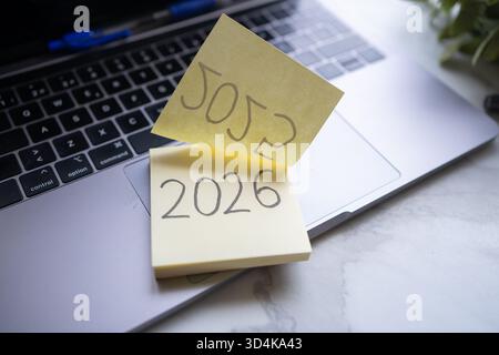 Sticky notes showing 2026 and 5052 numbers on a laptop keyboard Stock Photo