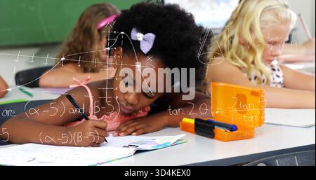 Writing girl wearing pink top purple bow leaning over workbook, class orange case math diagrams Stock Photo
