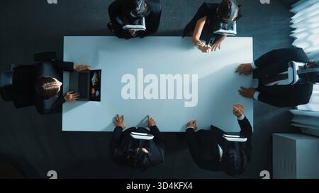 Top down aerial view of diverse data analysts wearing VR headset and stand around table while using hand gestures to manipulate the data streamed live Stock Photo