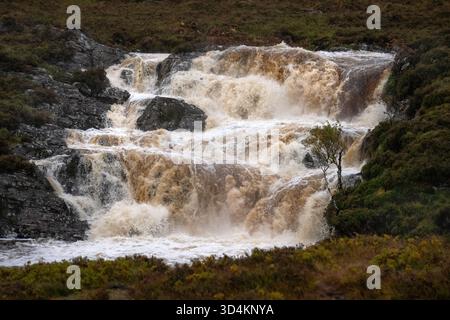 A waterfall in a small river in the Scottish Highlands, photographed in spate after heavy rain. Stock Photo