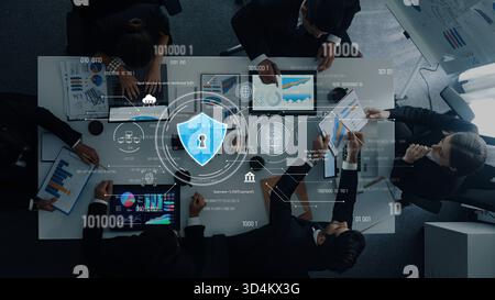 A top view of a professional business meeting focusing on cybersecurity analytics with digital lock icon overlay. Teams collaborate on data-driven Stock Photo