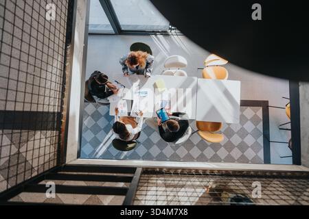 Top-Down View of a Collaborative Business Meeting With Documents, Tablets, and Charts in a Modern Office Stock Photo