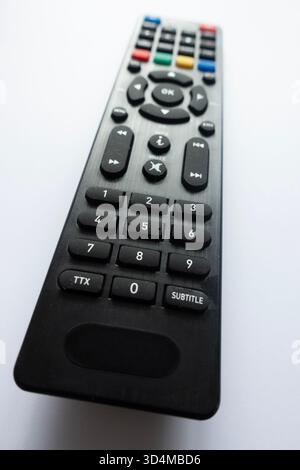 Close-up of a modern black TV remote control on white background showing buttons and details Stock Photo