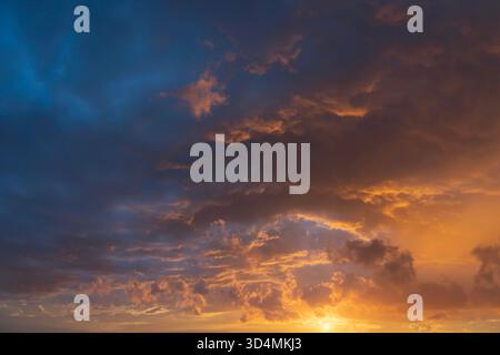 Glowing sky at sunset texture background overlay. Dramatic red, orange, and purple clouds. High resolution photography perfect for sky replacement Stock Photo