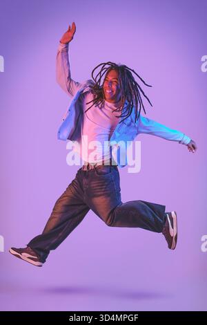 Young man with dreadlocks jumping with joy Stock Photo