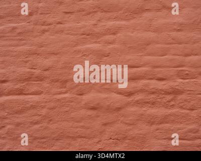 Matte reddish-orange brick wall with rough texture and visible joints. Copyspace Stock Photo