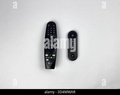 This is a flat lay or top-down view showing four different black remote controls scattered across a plain white background. Stock Photo
