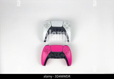 This is a flat lay or top-down photograph featuring two PlayStation 5 DualSense controllers stacked vertically and centered on plain white background Stock Photo