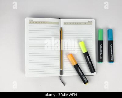 This is a flat lay or top-down view of a clean, minimalist workspace setup. The main subjects are lined notebook or journal and a modern devices Stock Photo