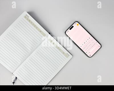 This is a flat lay or top-down view of a clean, minimalist workspace setup. The main subjects are lined notebook or journal and a modern devices Stock Photo