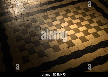 Old ceramic floor with wave pattern and vintage texture in moody sunlight, abstract geometric background. Selective focus. Stock Photo