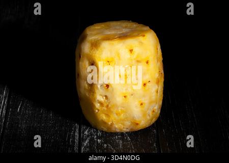 peeled pineapple on black wood background Stock Photo