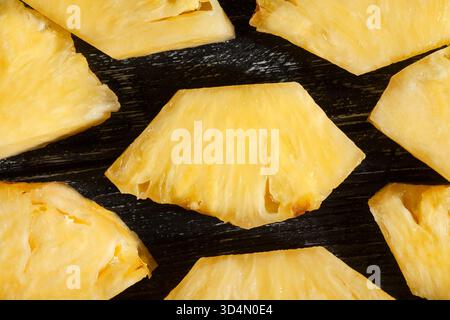 sliced pineapple on black wood background top view Stock Photo