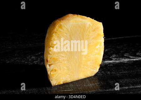 peeled sliced pineapple on black wood background Stock Photo