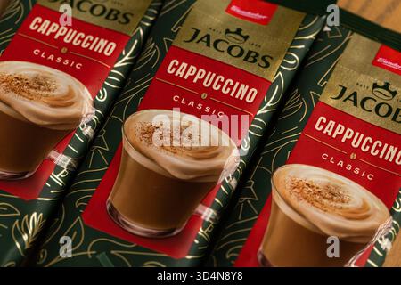 Lviv, Ukraine - November 11, 2025: Three Jacobs Cappuccino Classic Instant Coffee Sachets on Wood Stock Photo