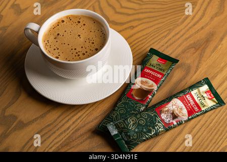 Lviv, Ukraine - November 11, 2025: Overhead View of Hot Cappuccino Cup and Jacobs Instant Sachets Stock Photo