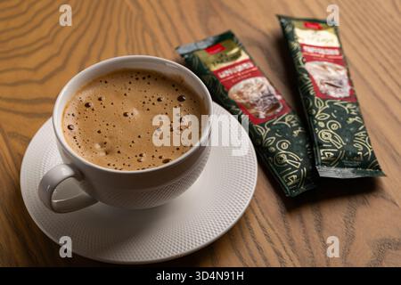Lviv, Ukraine - November 11, 2025: Overhead View of Hot Cappuccino Cup and Jacobs Instant Sachets Stock Photo