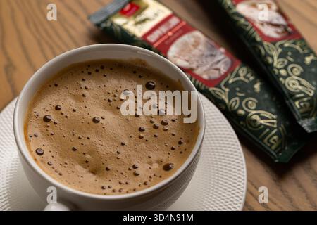 Lviv, Ukraine - November 11, 2025: Overhead View of Hot Cappuccino Cup and Jacobs Instant Sachets Stock Photo